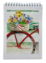 Load image into Gallery viewer, This is a watercolor of a red cruiser bicycle and behind the seat is a basket full of yellow blue and pink pansies with a small American flag dangling over the edge. This bike is leaning against a white fence.