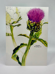 An Artichoke still attached to its stalk with the purplish hue of its 'flower' above.