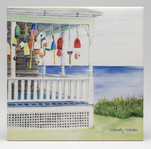 Load image into Gallery viewer, A ceramic tile with lobster buoys hanging from the porch beams looking out to sea on the cliff's edge.