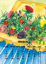 Load image into Gallery viewer, March calendar page featuring a colorful watercolor-style illustration of flowers and an Easter egg in a basket, with a blue striped picnic blanket and black weekday labels at the bottom.
