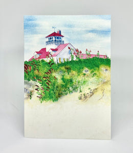 Standing on the beach looking up towards the Coast Guard Beach Lighthouse with sea grass in the forefront and of course the beach.