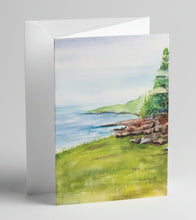 Load image into Gallery viewer, A hand cut greeting card featuring a watercolor painting of the Maine coast with a grassy foreground and tree-lined cliffs over looking the ocean.