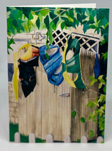 Load image into Gallery viewer, Lifejackets drying on the stockade walls of the outdoor shower.  The shower head is peeking up above and there is lattice work on the house as well as a tree branch acting as a canopy for the shower.