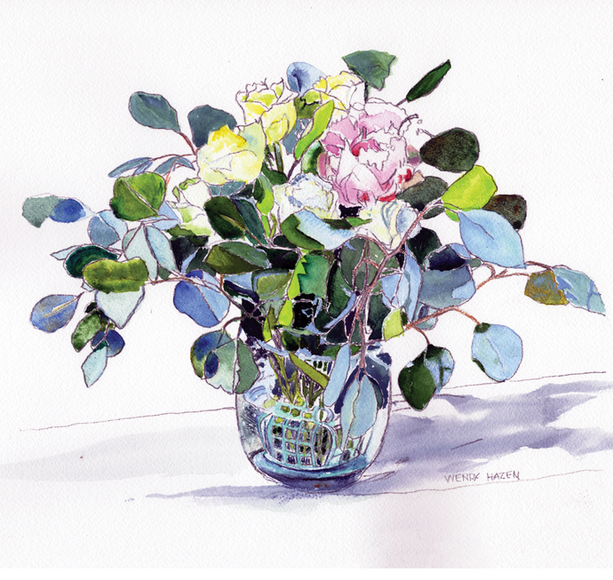 A vase filled with white and red variegated roses with Eucalyptus leaves throughout.
