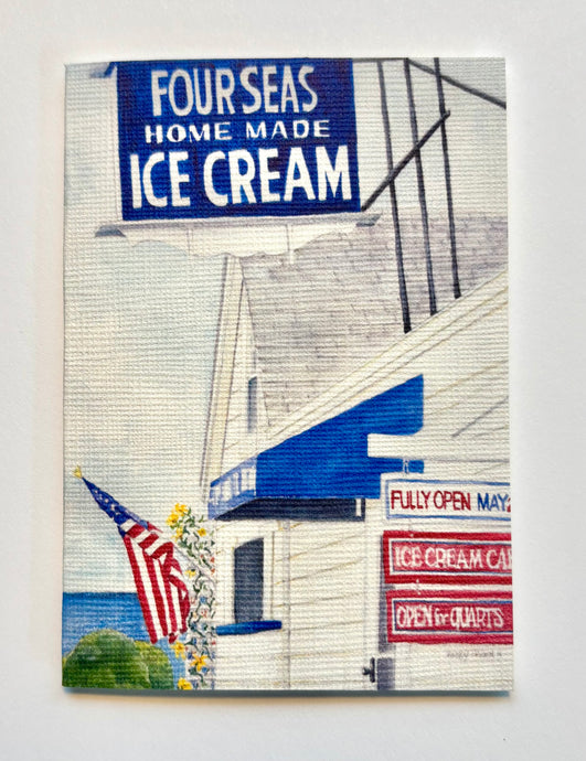 Shows the Blue and White ice cream sign as well as the front of the building with the American Flag and an artist's addition - a view to the sea!