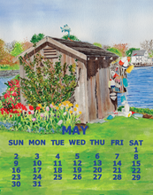Load image into Gallery viewer, A watercolor-style May calendar page featuring a small wooden garden shed by a lake, flowers, and a blue sky. The bottom section shows the days of the week in blue text over a green lawn.