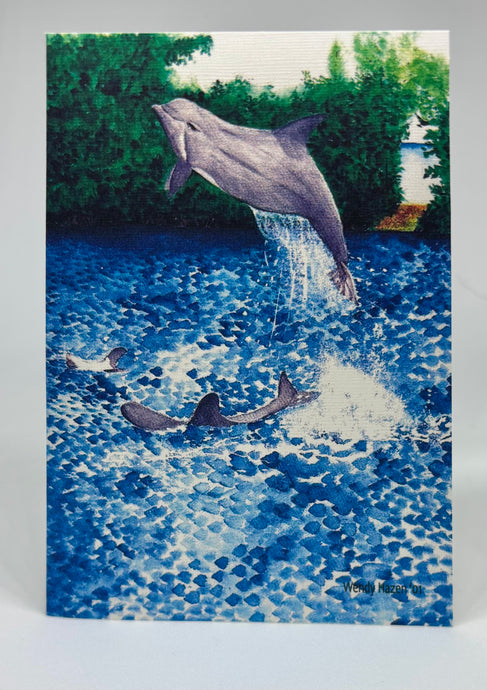 A dolphin jumping out and over the other dolphins swimming about.