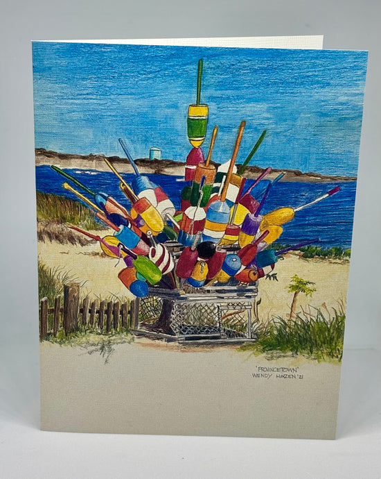 located near the beach an old worn wooden lobster trap holds captive about 20 lobster buoys.  Very colorful with the Provincetown water tower in the background as well the waters of Cape Cod Bay.