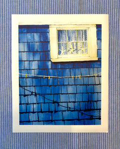 Artistic depiction of a Fisherman's cottage blue weathered wall with a white window with a lace curtain and 3 starfishes' 
