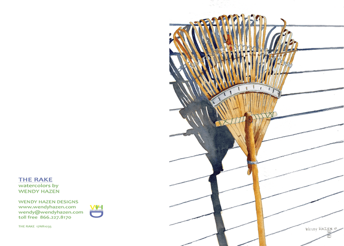 Leaning against the side of a white house is a bamboo rake with afternoon shadows.