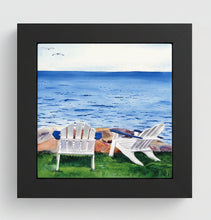 Load image into Gallery viewer, Two Adirondack chairs sitting on the lawn facing the water with a large rock in place.  And the ocean is mildly choppy with two seagulls in the upper left corner in a light blue sky.  Placed in a black wooden frame 