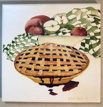 Load image into Gallery viewer, A pie with criss cross crust on top with a bit of the berry juice running down the front of the pie plate.  And a bowl with apples and a green gingham drying towel in the background