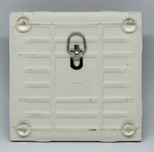 Load image into Gallery viewer, back of a PLAIN tile with 4 bumpons and a folding medal hanger.