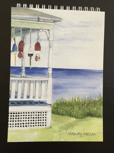 Lobster Buoys on the front porch of a summer cottage looking out to sea notepad with 100 blank pages