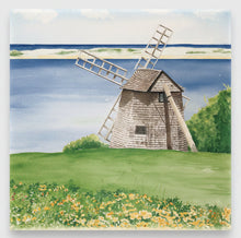 Load image into Gallery viewer, A ceramic tile of a windmill in a field with flowers, trees and water with a dune in the background.
