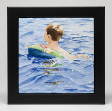 Load image into Gallery viewer, A ceramic tile of a 5 year old with his sipderman inner tube swimming along with a wooden black frame