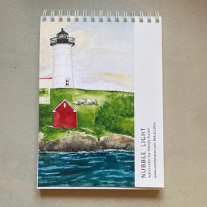 This the back cover of the Nubble Lighthouse Notepad with the actual lighthouse and the small red building close to the water's edge.  Nubble is located in York, Maine and is probably one of the most photographed and painted lighthouses of Maine